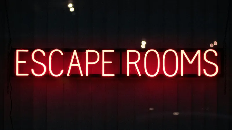 Czerwony neon z napisem Escape Rooms na ciemnej ścianie